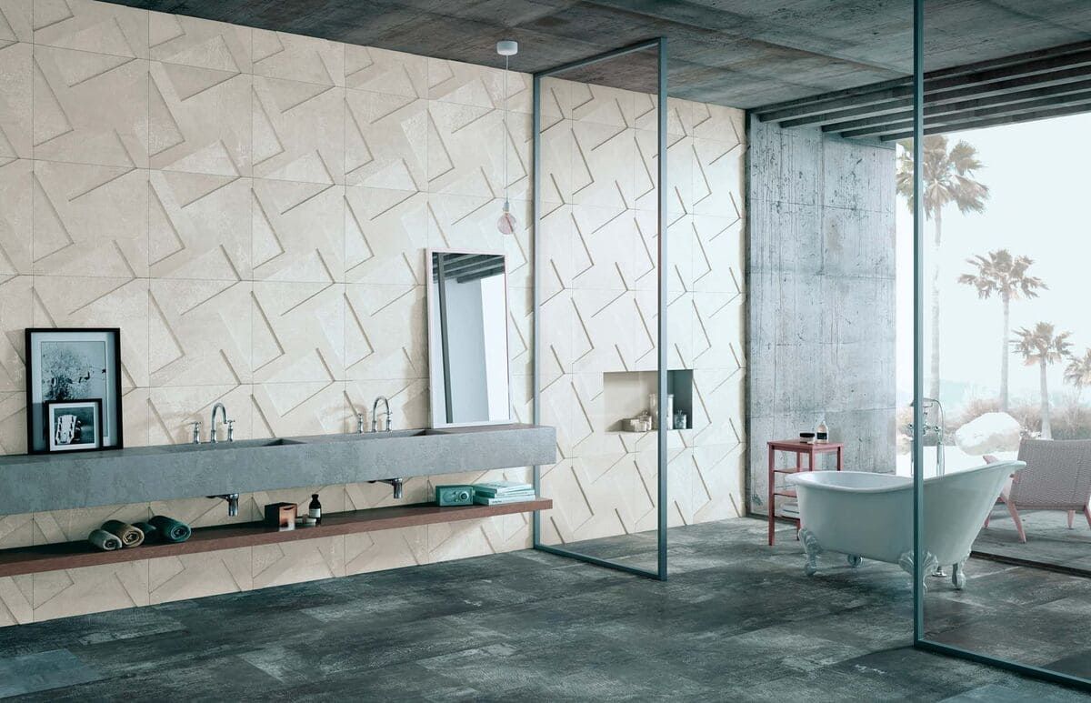 Baño moderno con pared geométrica beige, lavabo y suelo de hormigón y bañera independiente.