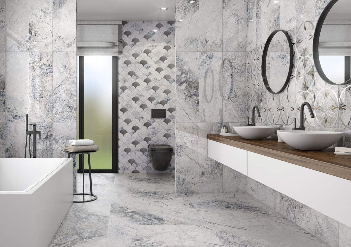 Baño moderno con azulejos estampados en azul y blanco, bañera profunda y tocador flotante.