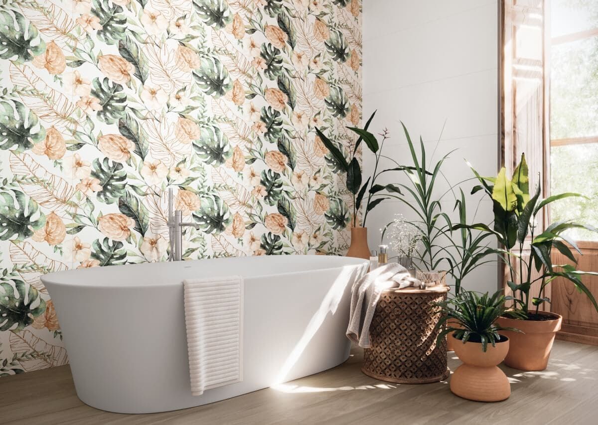 Baño con bañera blanca, papel tapiz floral y plantas en macetas.