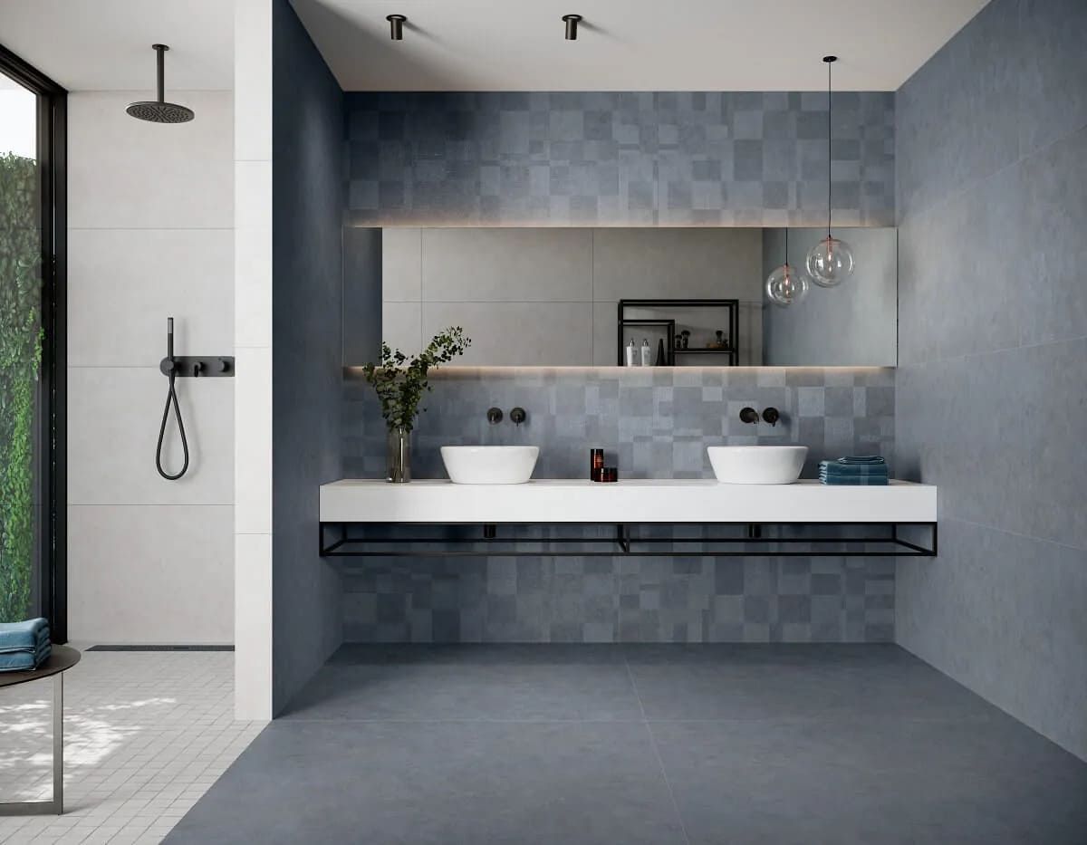 Baño moderno con paredes azules, lavabos blancos y un espejo grande.