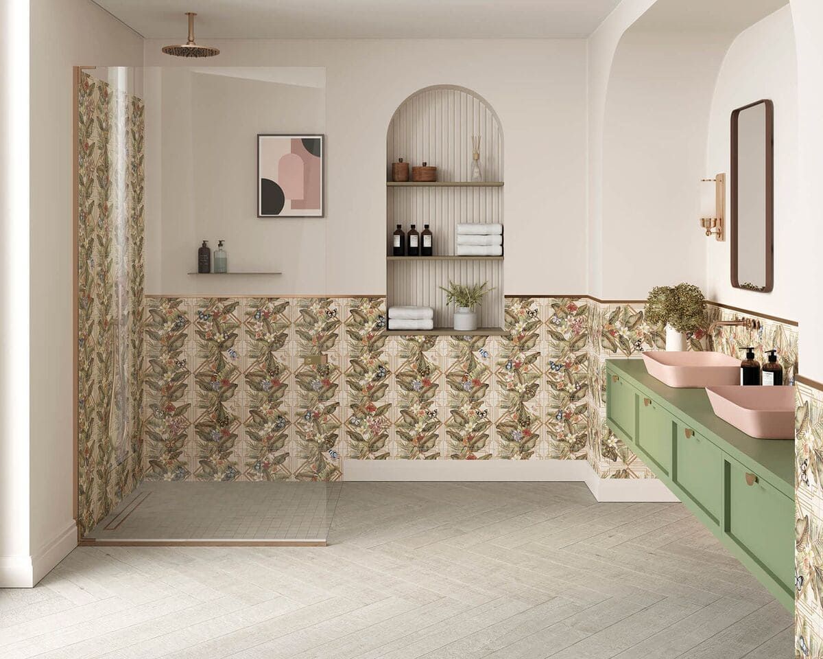 Baño con detalles de azulejos florales, tocador verde, estantes arqueados y espejo enmarcado.