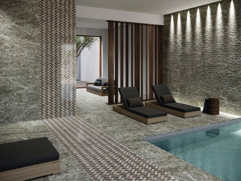 Spa de lujo con piscina y tumbonas; paredes y suelos de baldosas de piedra; tonos neutros.