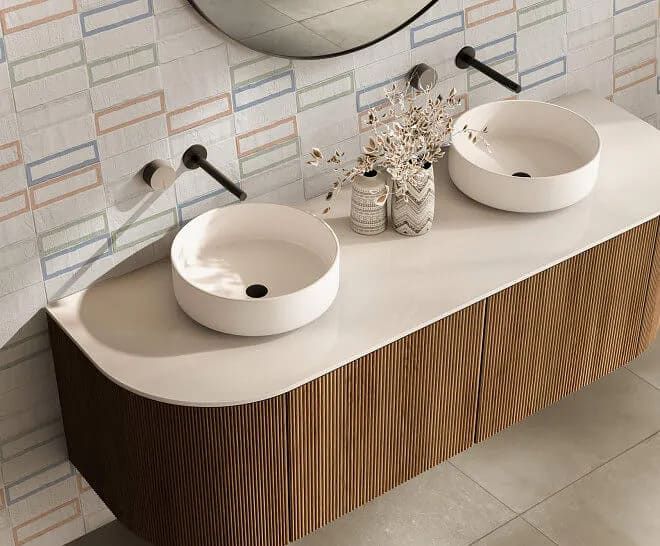 Mueble de baño con dos lavabos blancos, grifería negra y mueble de madera texturizada.