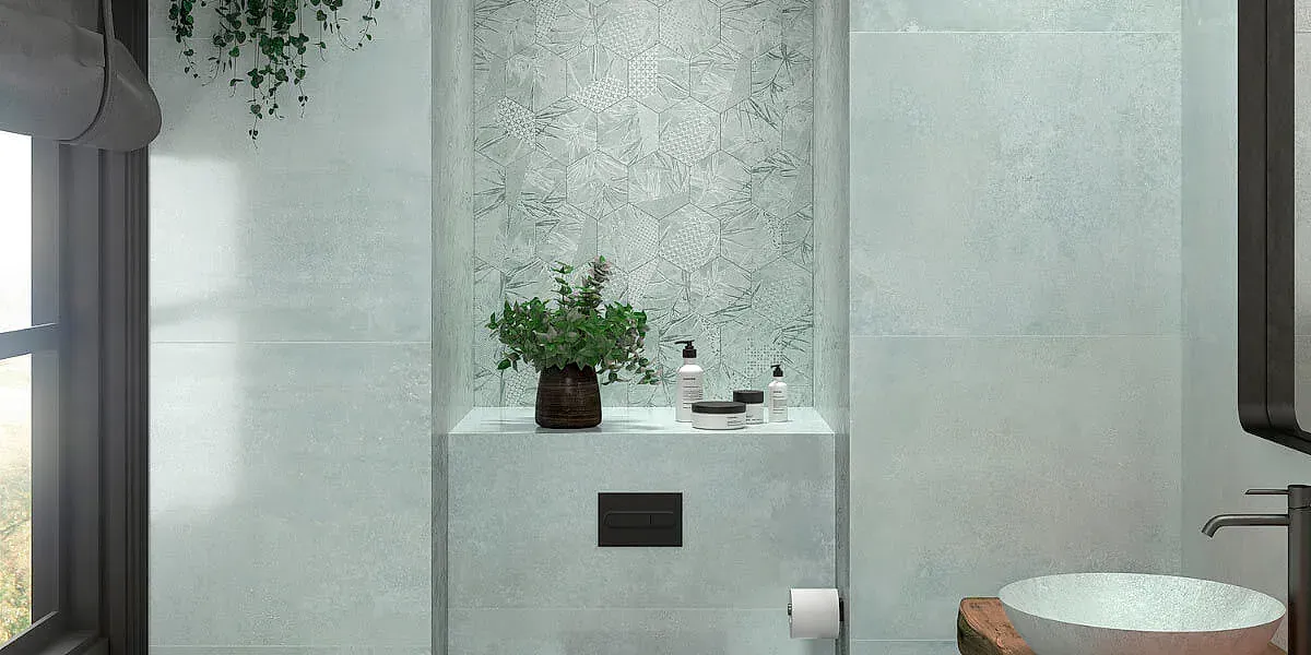 Interior de baño con paredes de color verde claro, un estante empotrado con plantas y artículos de tocador y un lavabo.