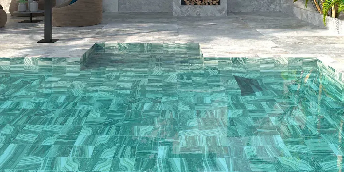 Piscina con agua turquesa, aleta de tiburón visible y fondo de patio de piedra.