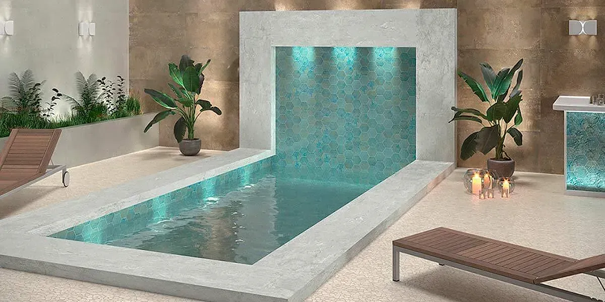 Piscina cubierta con fuente de agua, plantas en macetas, tumbonas y velas.