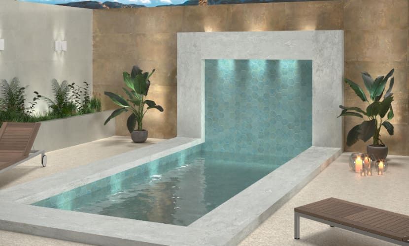 Moderna piscina al aire libre con cascada, plantas y tumbonas.