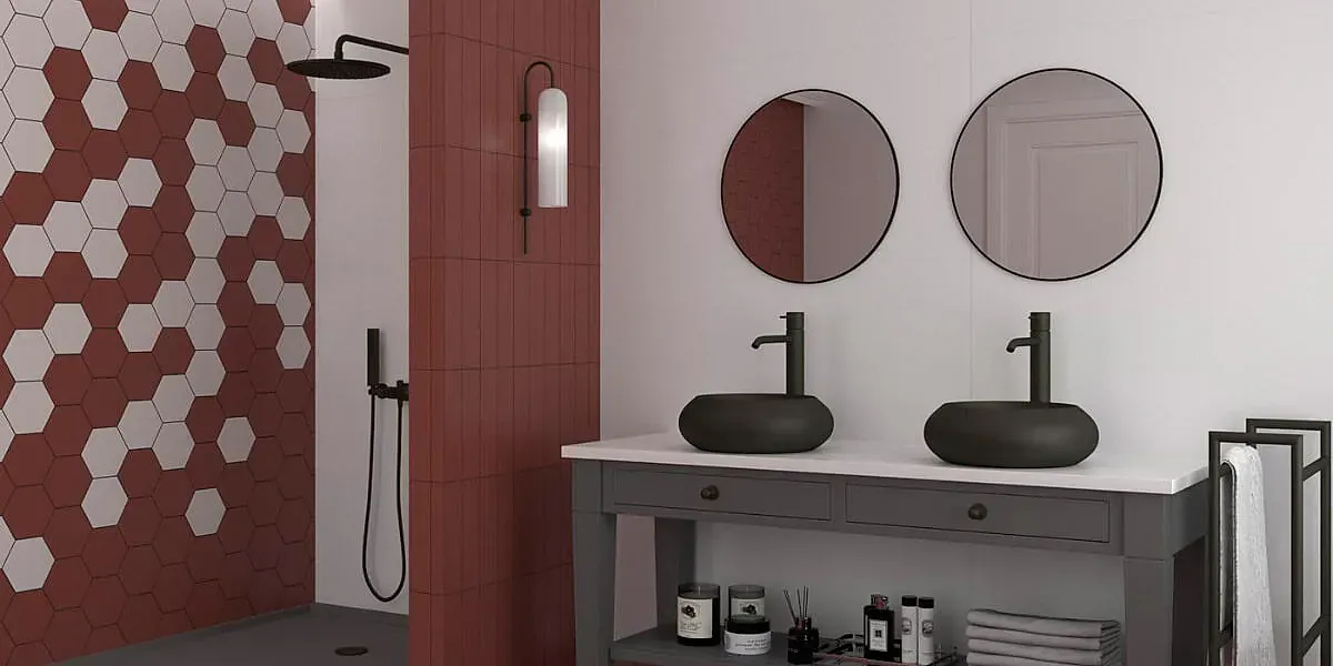 Baño con paredes rojas, ducha con azulejos hexagonales y lavabos de color verde oscuro sobre un tocador gris.