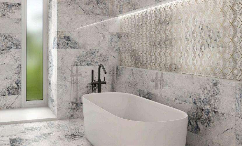 Baño con bañera blanca, paredes de mármol, ventana y detalles de azulejos estampados.