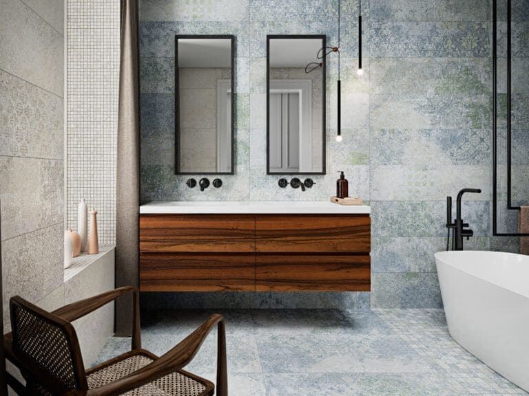 Baño con paredes de azulejos con dibujos azules, tocador de madera y bañera independiente.