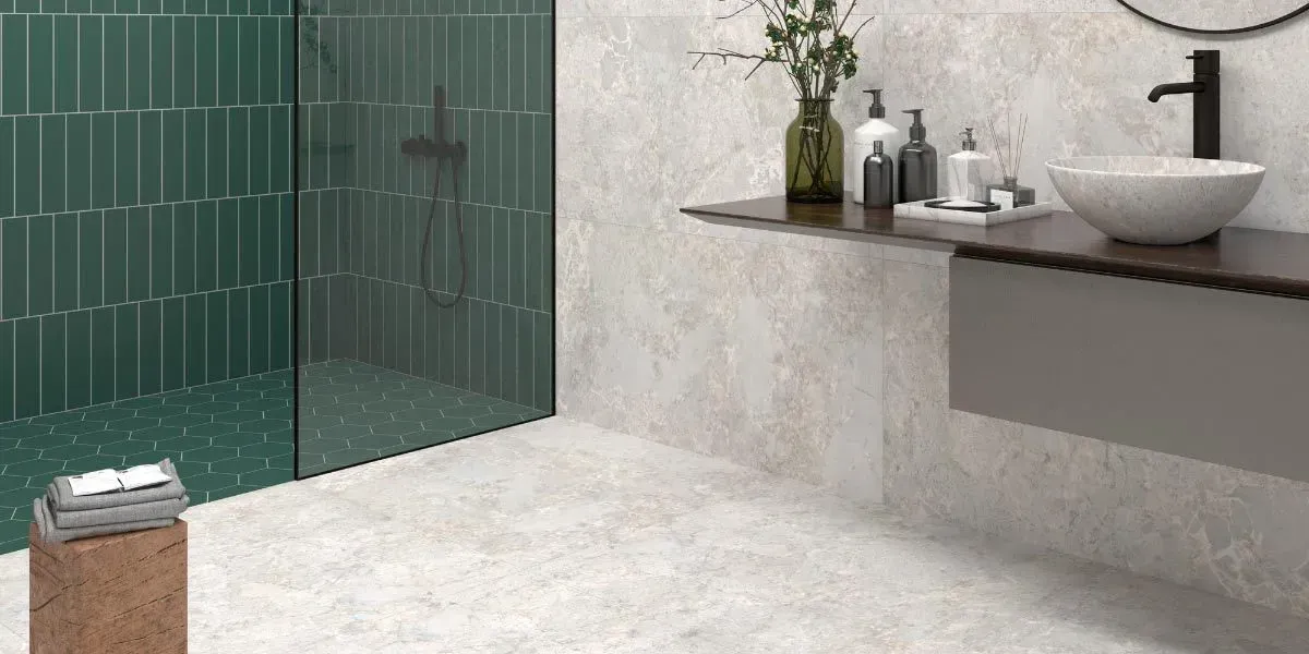 Baño con ducha de azulejos verdes, tocador gris y lavabo blanco.