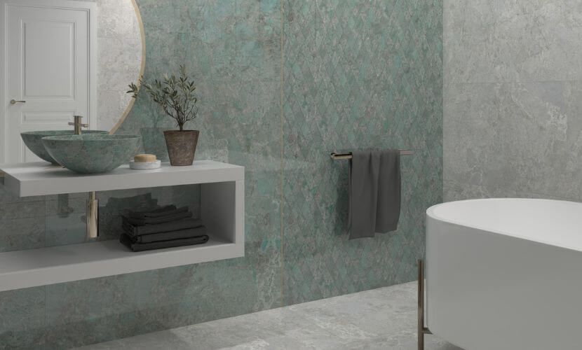 Baño con pared verde azulado, tocador flotante blanco, espejo redondo y bañera blanca.