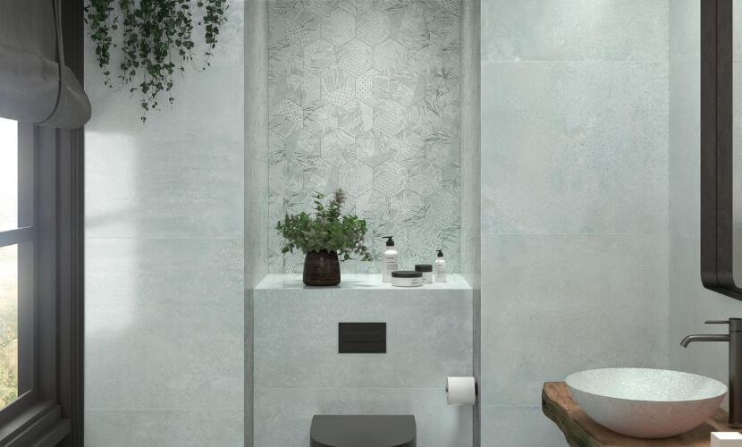 Baño moderno con paredes de azulejos grises, estante empotrado con plantas y artículos de tocador y lavabo.