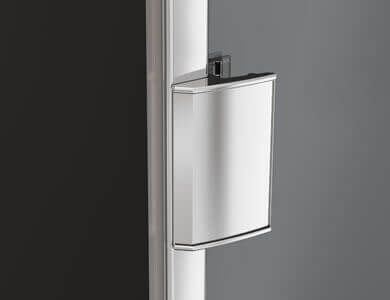 Contenedor de basura plateado montado en un poste blanco, fondo gris.