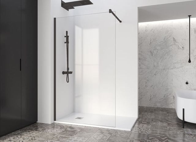 Ducha moderna con marco y accesorios negros, contra pared blanca; piso de mármol y bañera al fondo.