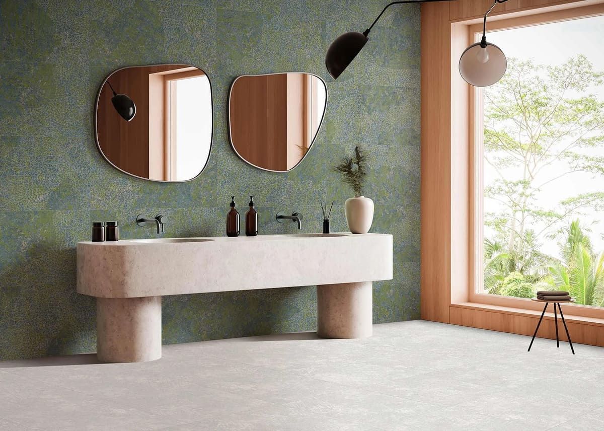 Baño moderno con lavabo de piedra, dos espejos y un gran ventanal con vistas a la vegetación.