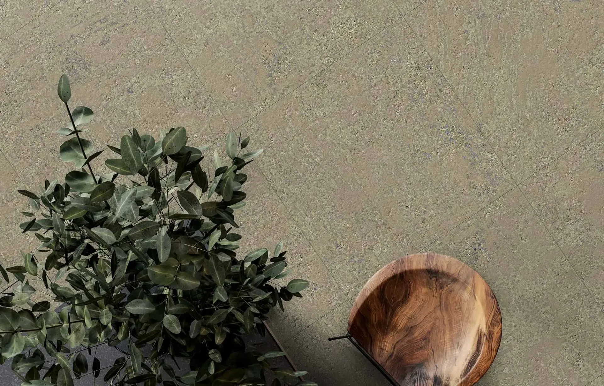 Una cuchara de madera reposa sobre una superficie moteada y de color canela, junto a una planta de hojas verdes.