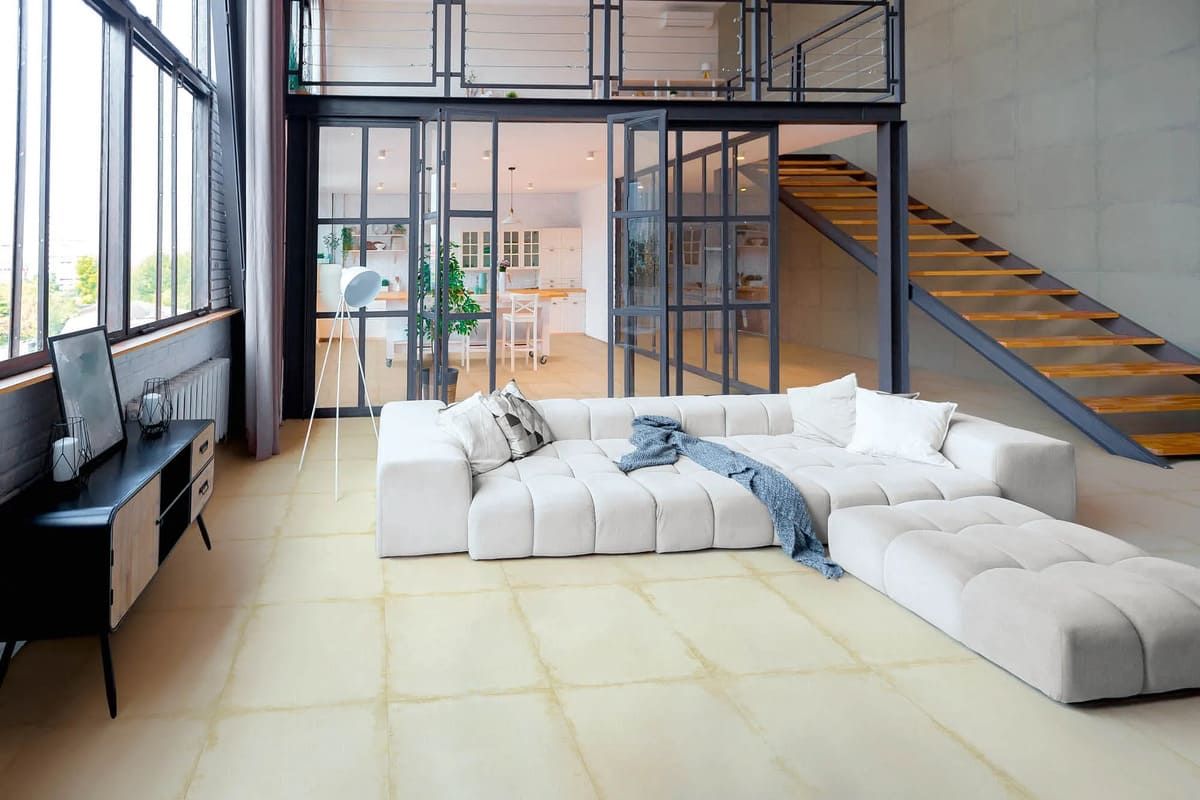 Sala de estar moderna con sofá blanco, paredes de cristal y escalera. Suelo de baldosas claras.