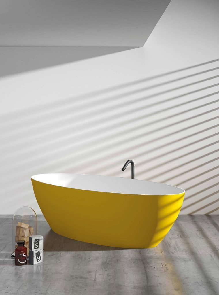 Bañera ovalada amarilla contra una pared blanca con grifo oscuro y cortinas de ventana.