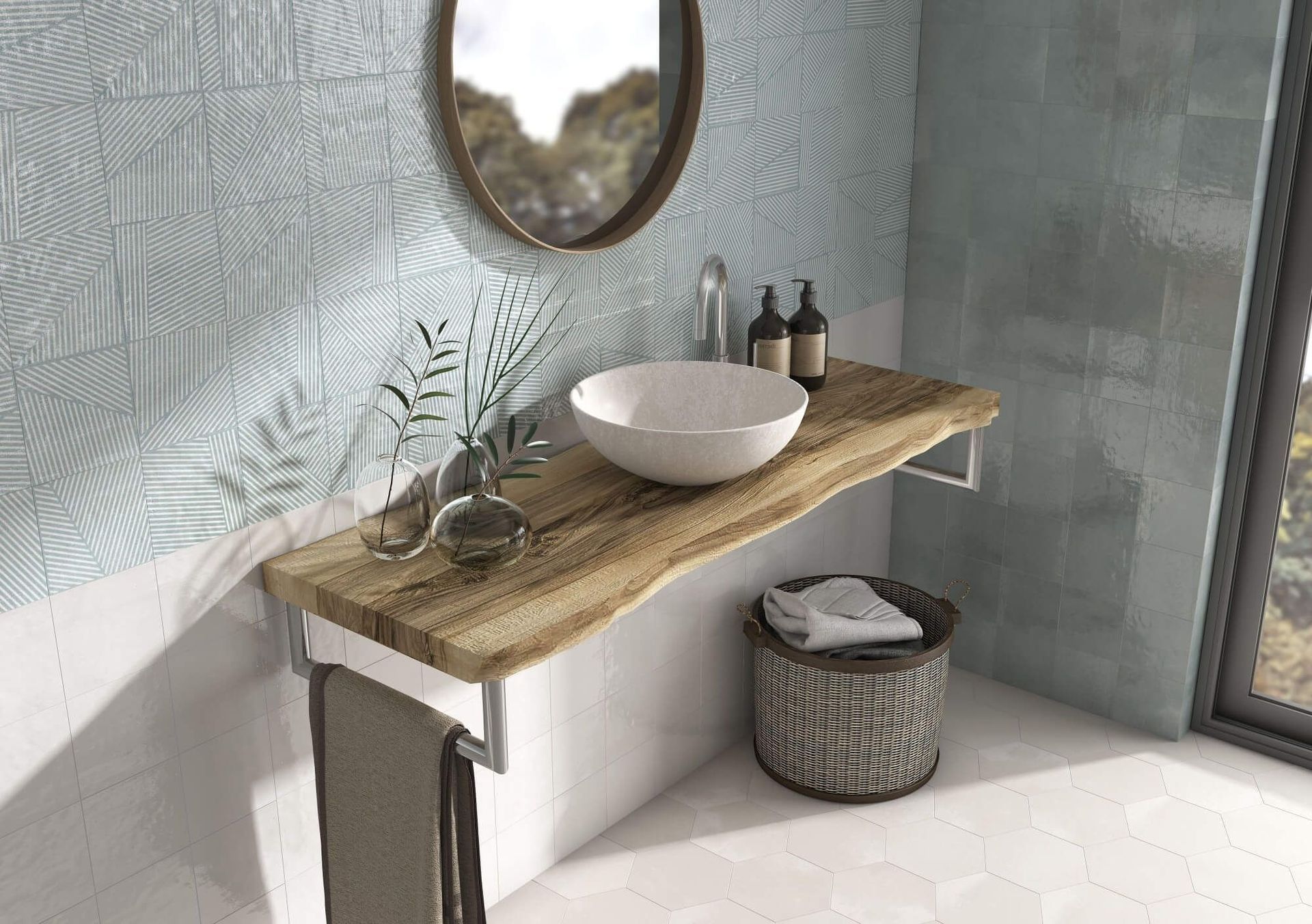 Baño con tocador de madera, lavabo sobre encimera y espejo redondo. Papel pintado azul con estampados y luz natural.