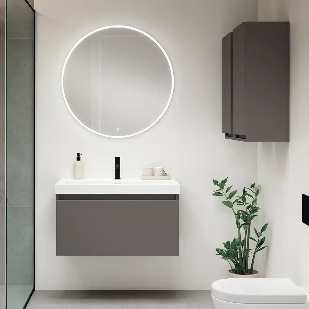 Baño moderno con tocador gris, espejo redondo y mueble de pared.