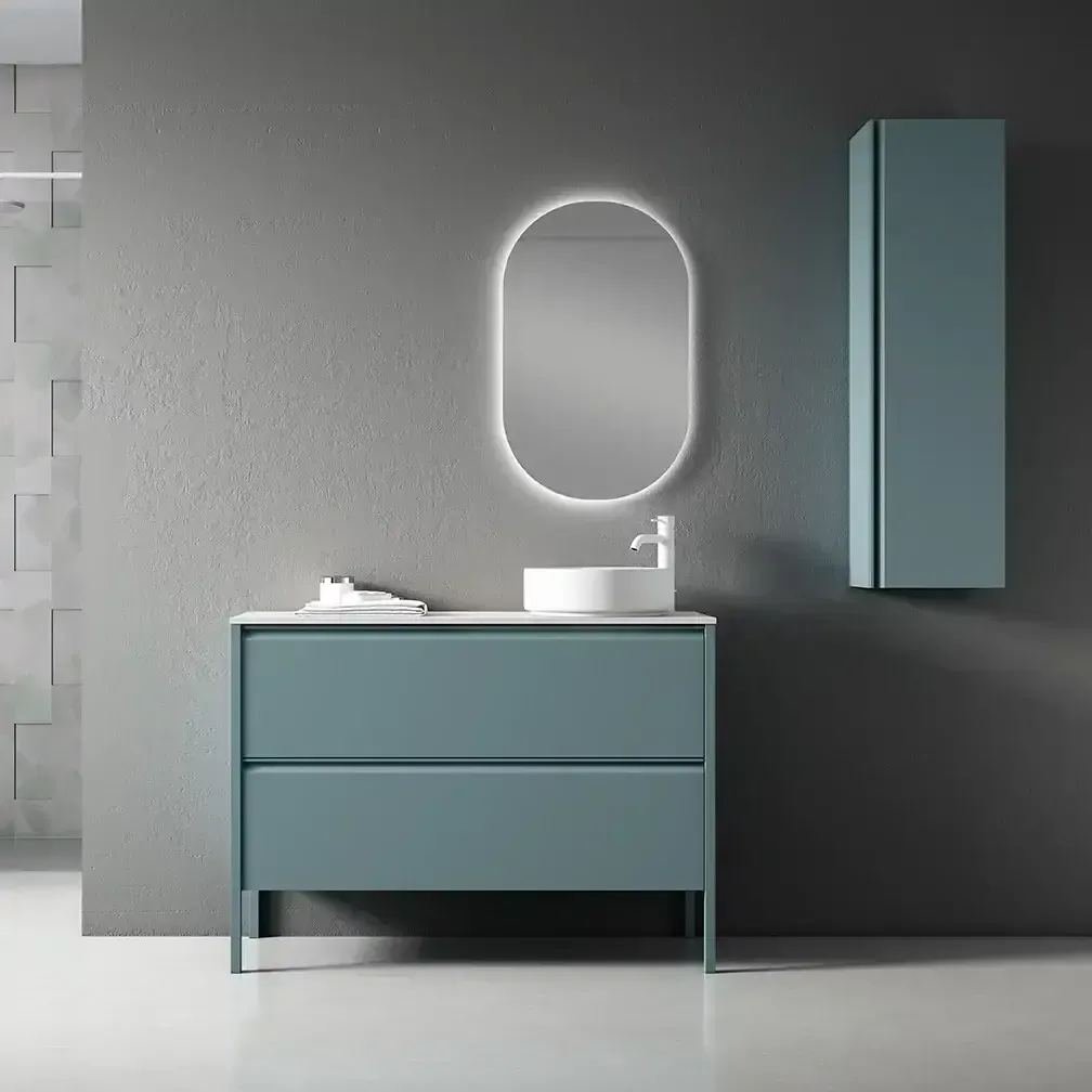 Tocador de baño azul con lavabo, espejo y mueble contra pared gris.
