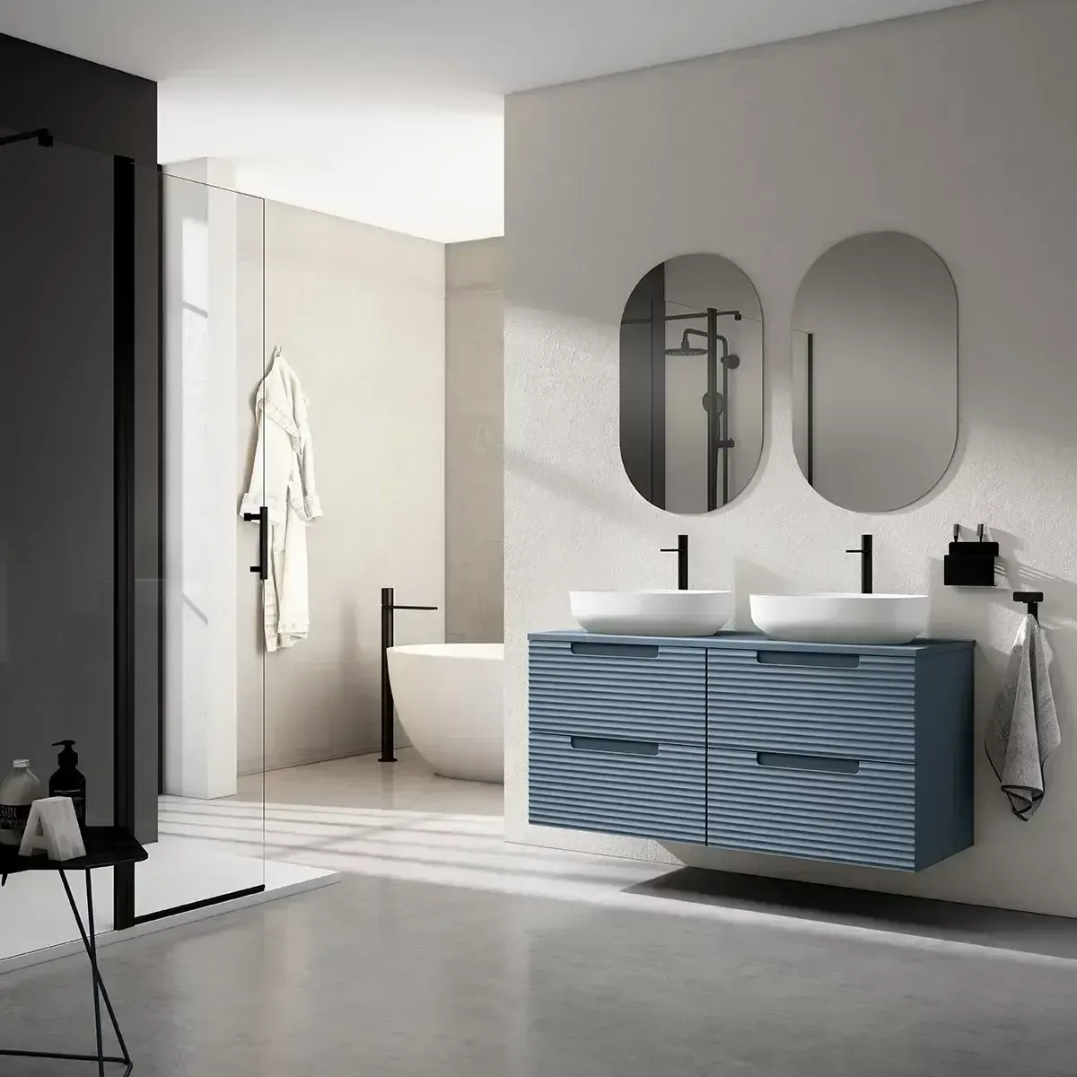 Mueble de baño moderno de color azul con dos lavabos, espejos ovalados y ducha tras un cristal.