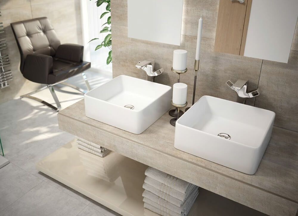 Baño moderno con lavabos cuadrados, velas y silla.