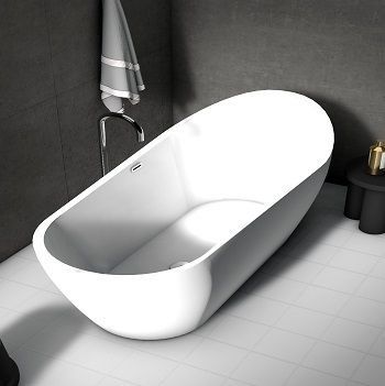 Bañera independiente ovalada de color blanco en un baño con paredes de color gris oscuro y suelo de baldosas blancas.