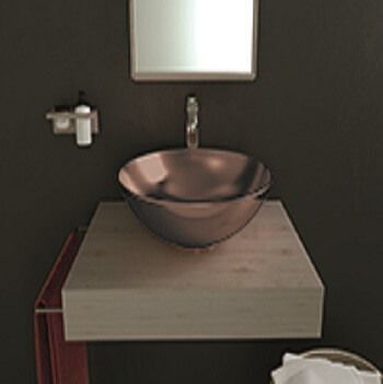 Lavabo de bronce sobre encimera flotante gris en un baño moderno con espejo y paredes oscuras.