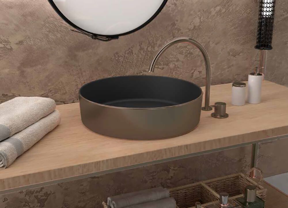 Lavabo de baño con toallas, grifo y accesorios sobre encimera de madera.