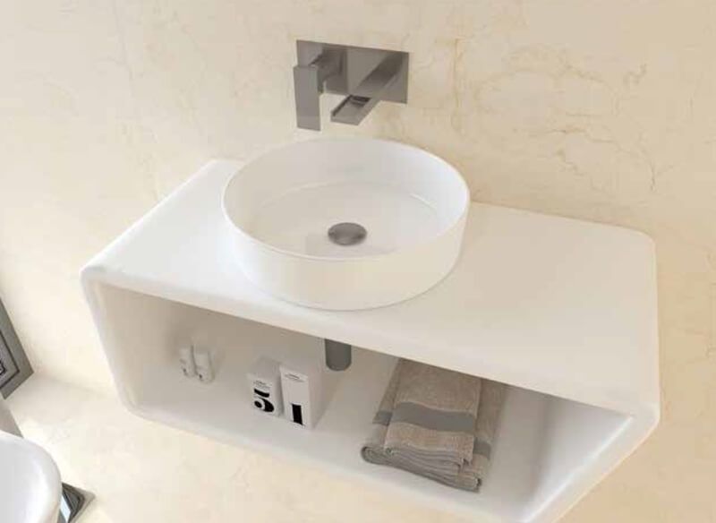 Lavabo de baño moderno y blanco con grifo sobre estante flotante blanco, toallas y artículos de tocador.