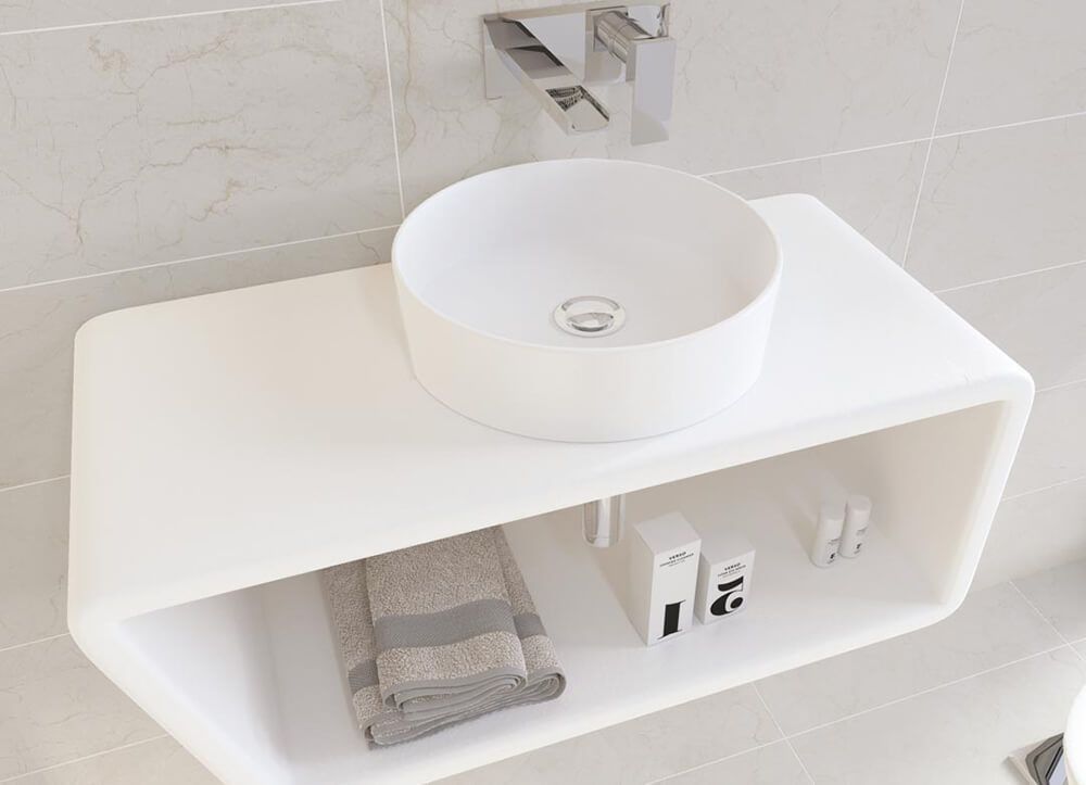 Lavabo de baño moderno de color blanco con estante sobre la encimera; toallas y artículos de tocador en el estante, grifo montado en la pared.