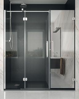 Mampara de ducha de cristal con puerta, herrajes plateados, cabezal de ducha y toalla.