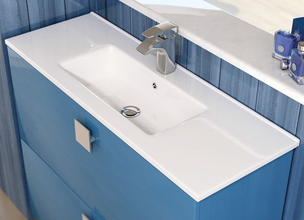 Mueble de baño azul con lavabo rectangular blanco y grifería cromada.