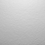 Superficie gris texturizada, posiblemente piedra o material rugoso.