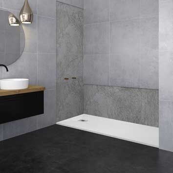 Baño moderno con azulejos grises, lavabo blanco, encimera negra y ducha a ras de suelo.