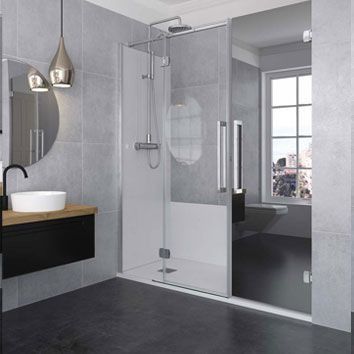 Baño moderno con mampara de ducha de cristal, tocador y gran ventanal.