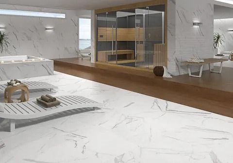 Interior de spa de lujo con pisos de mármol blanco, sauna y sillones.