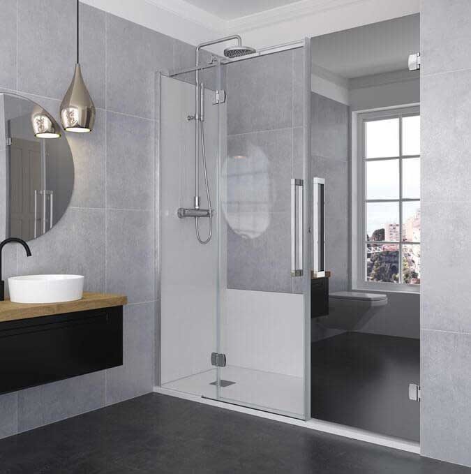 Baño moderno con mampara de ducha de cristal, tocador negro y espejo redondo.