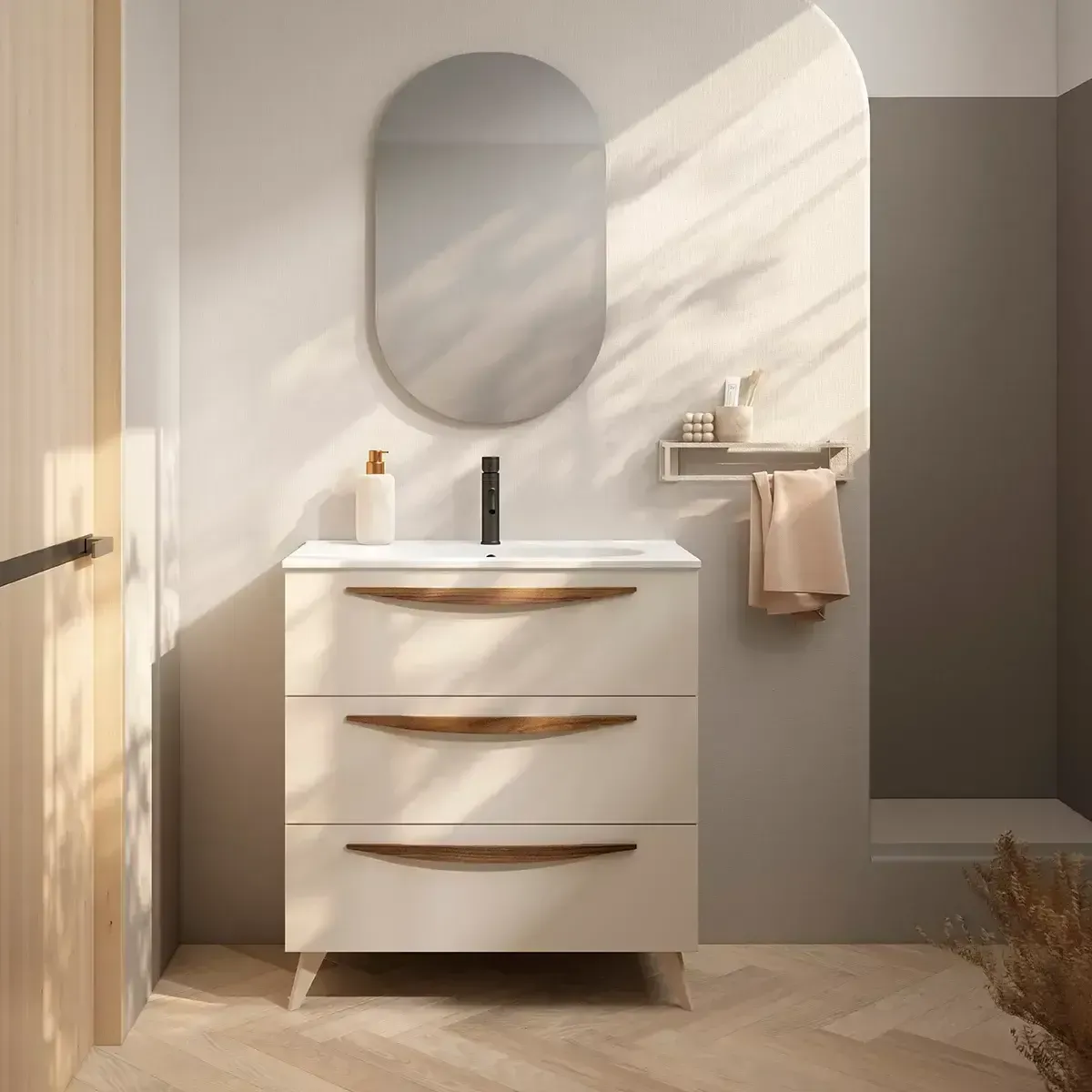 Mueble de baño beige con tres cajones, espejo ovalado y toallero.