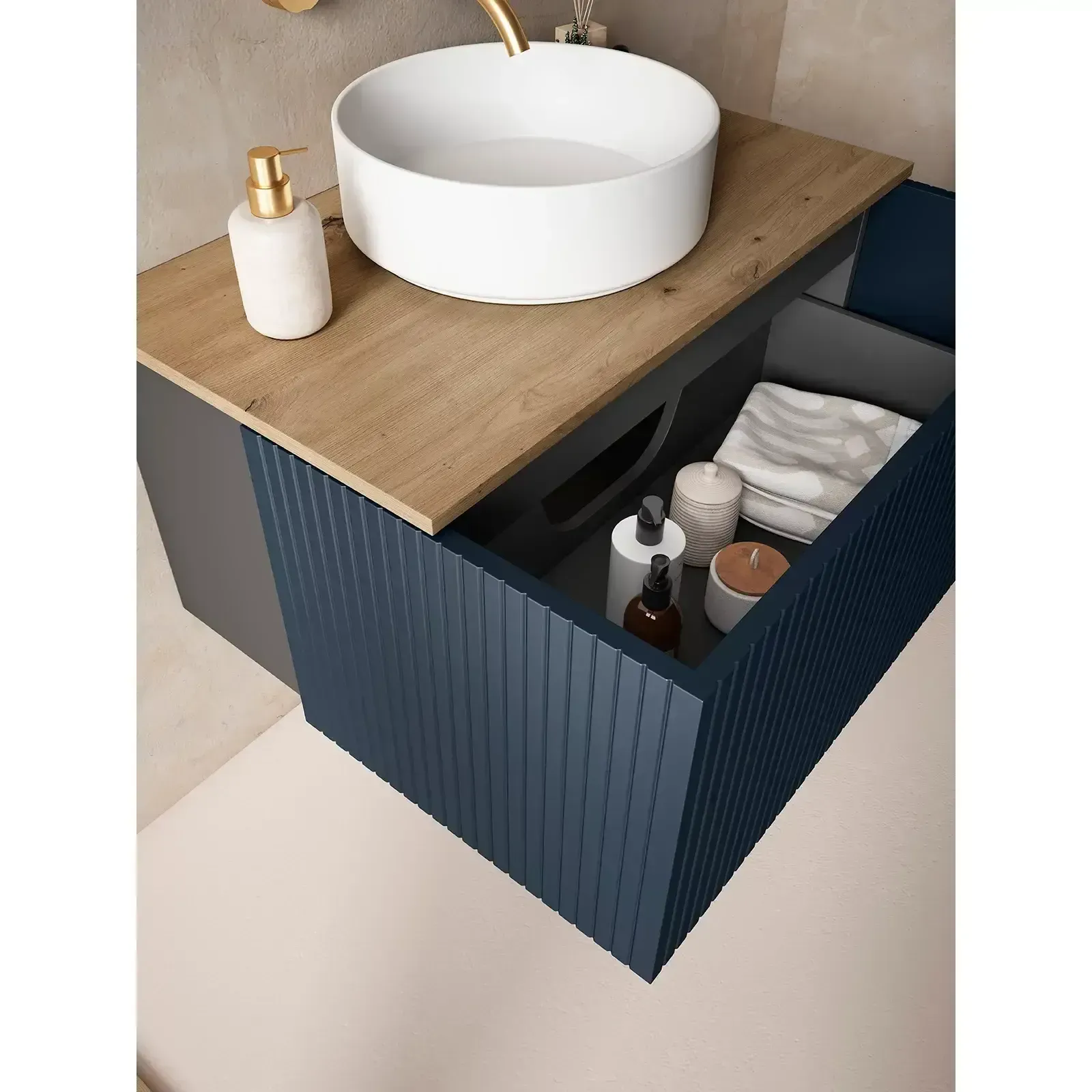 Mueble de baño con cajón abierto texturizado en color azul, lavabo en color blanco y encimera de madera.
