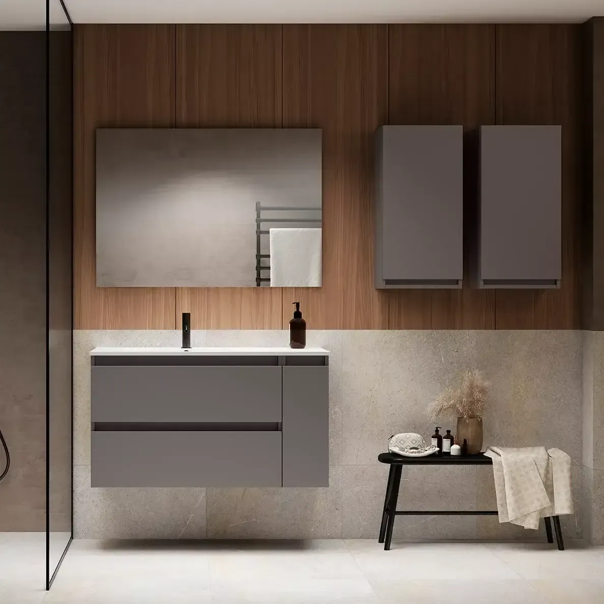 Baño moderno con tocador gris, espejo, armarios y ducha. Hay una mesita con toallas al frente.