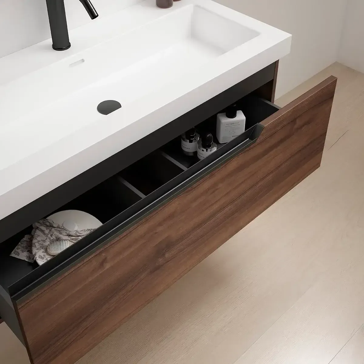 Mueble de baño con cajón abierto, encimera blanca, grifería negra, frente de madera, interior negro, suelo beige.