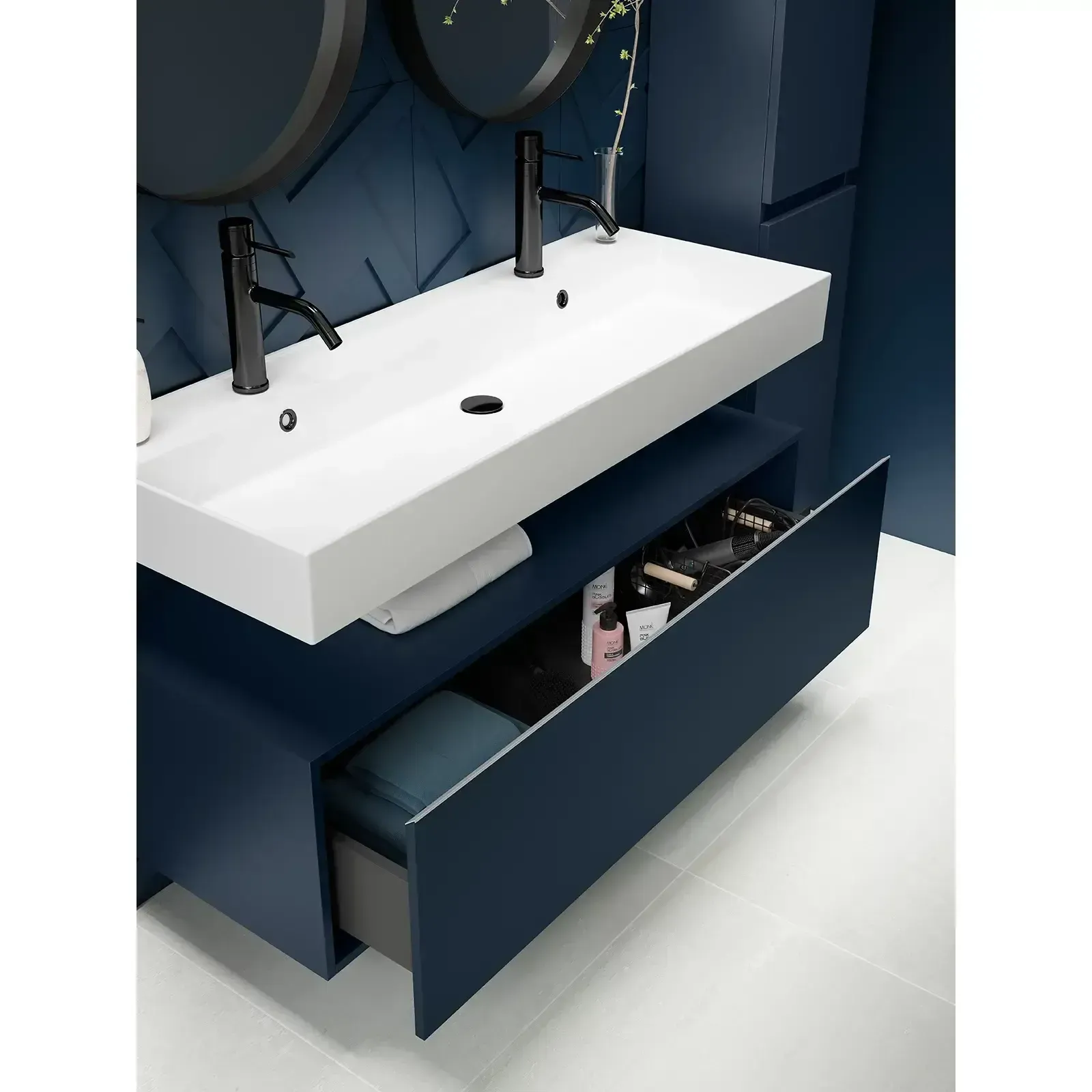 Mueble de baño moderno con mueble azul marino y lavabo rectangular blanco con grifería negra.