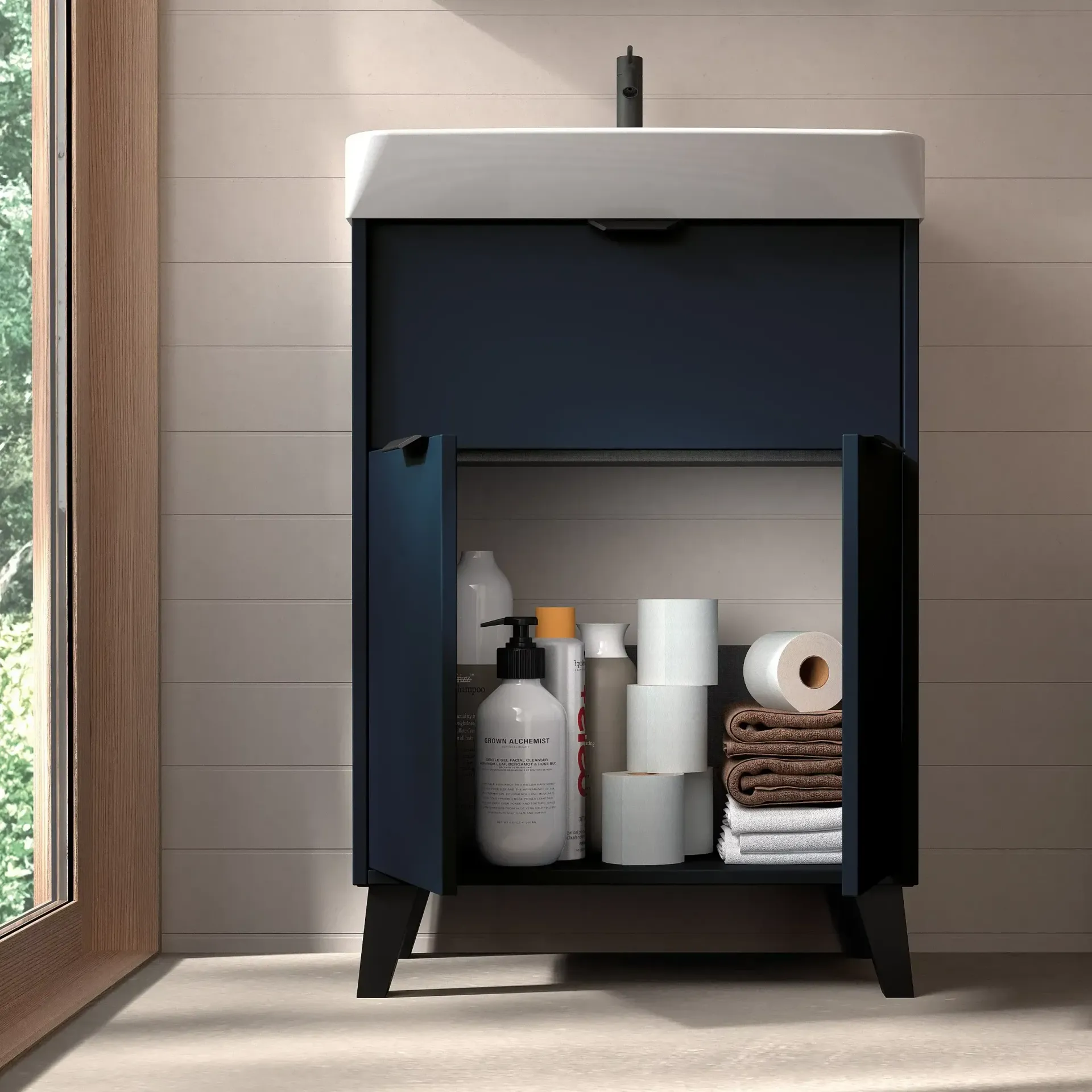 Mueble de baño de color azul marino con puertas abiertas, con artículos de tocador y toallas.