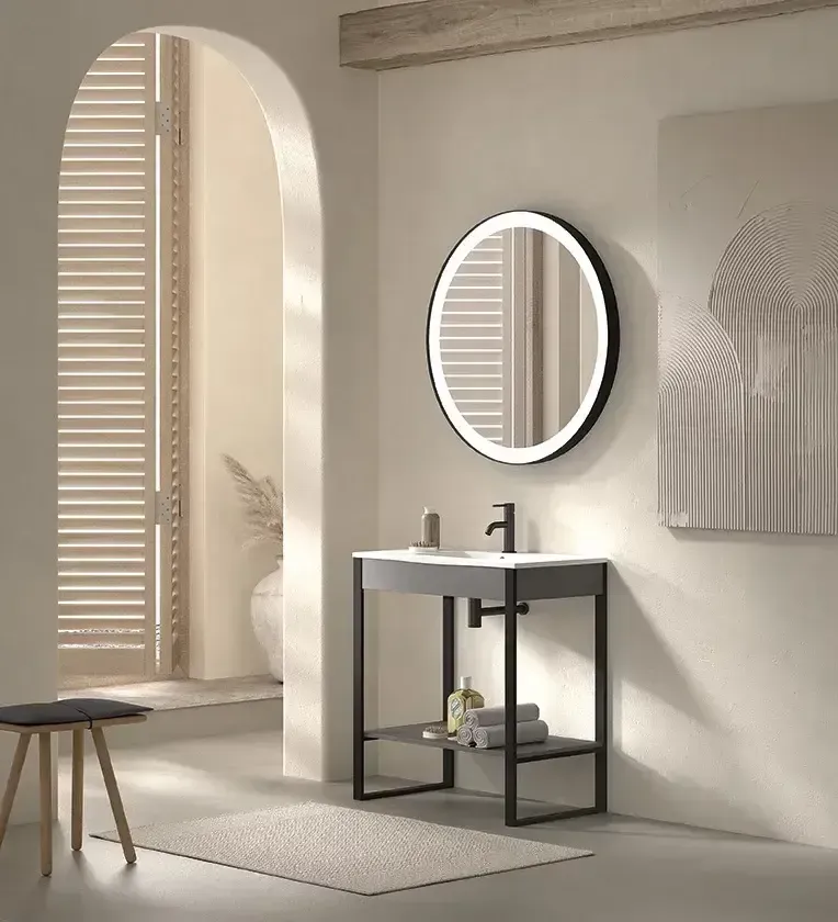 Baño moderno con tocador, espejo redondo y puerta arqueada con contraventanas.