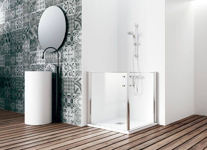 Baño moderno con ducha de vidrio, lavabo con pedestal y pared con acento de azulejos estampados.