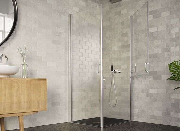 Ducha con paredes de cristal en un baño; un tocador y un espejo están a la izquierda.