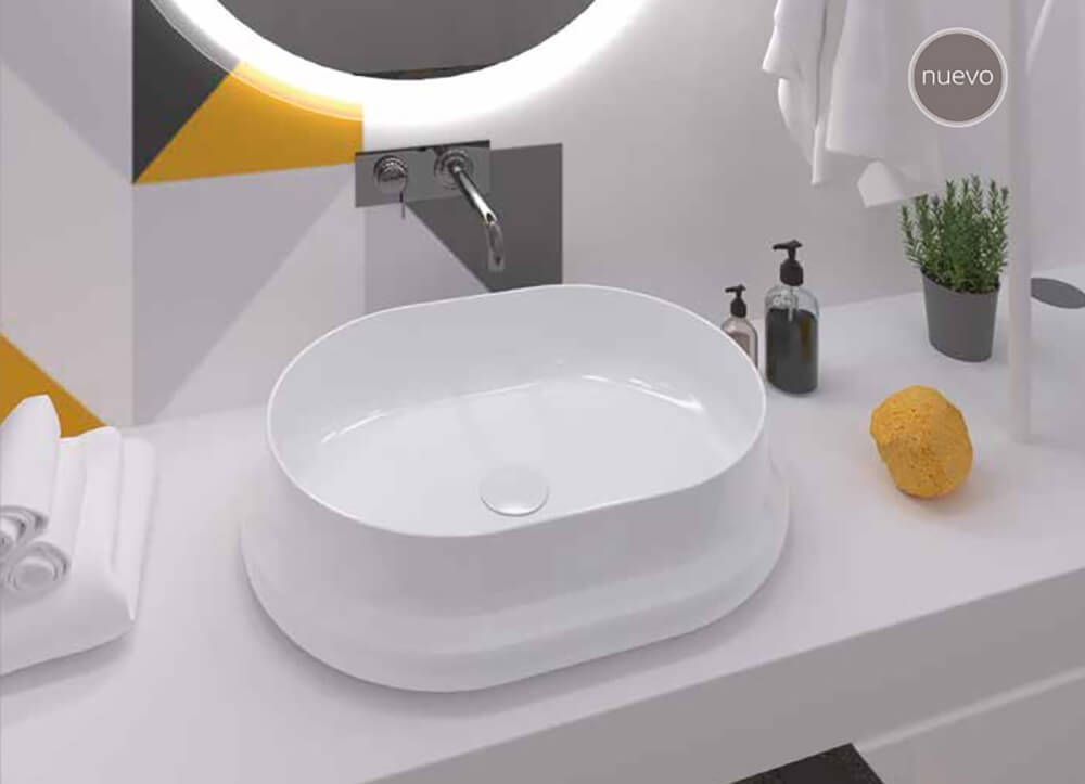 Lavabo ovalado blanco con grifo cromado, jabón y esponja. Diseño moderno con decoración geométrica en la pared.